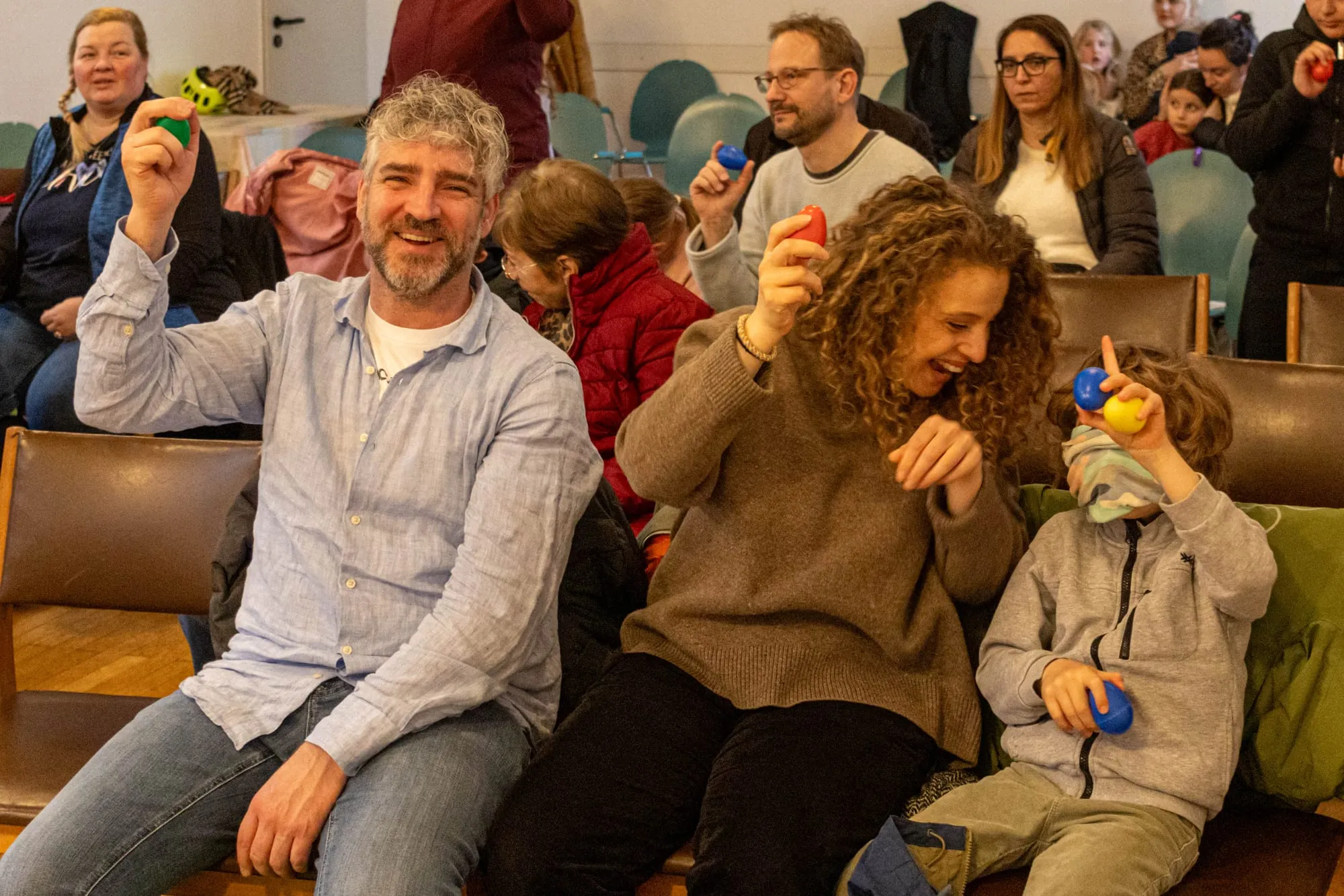 Eltern und Kinder machen mit Rassel-Eiern beim Jazzkonzert mit